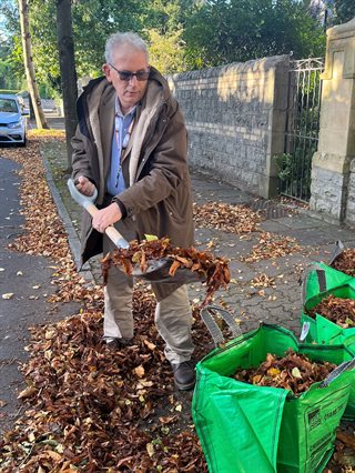 Counselor Wilson sweeping leaves